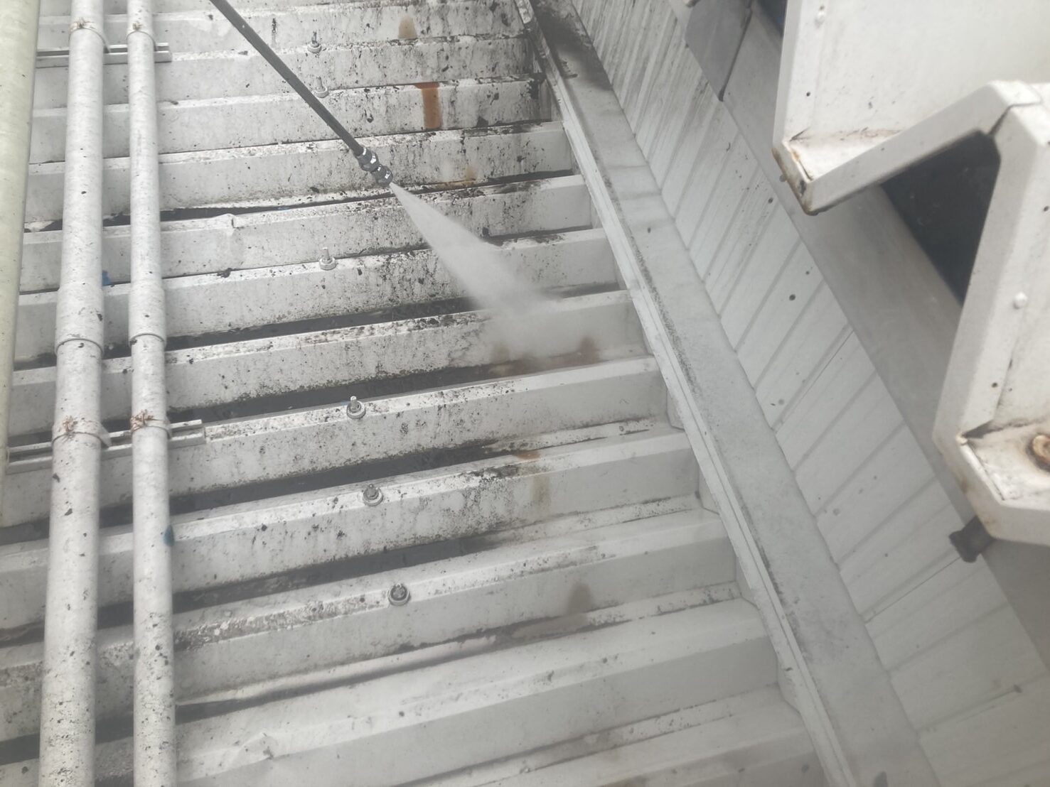 折板屋根の汚れを高圧洗浄で丁寧に落とす作業風景｜浜松市 車検工場塗装工事